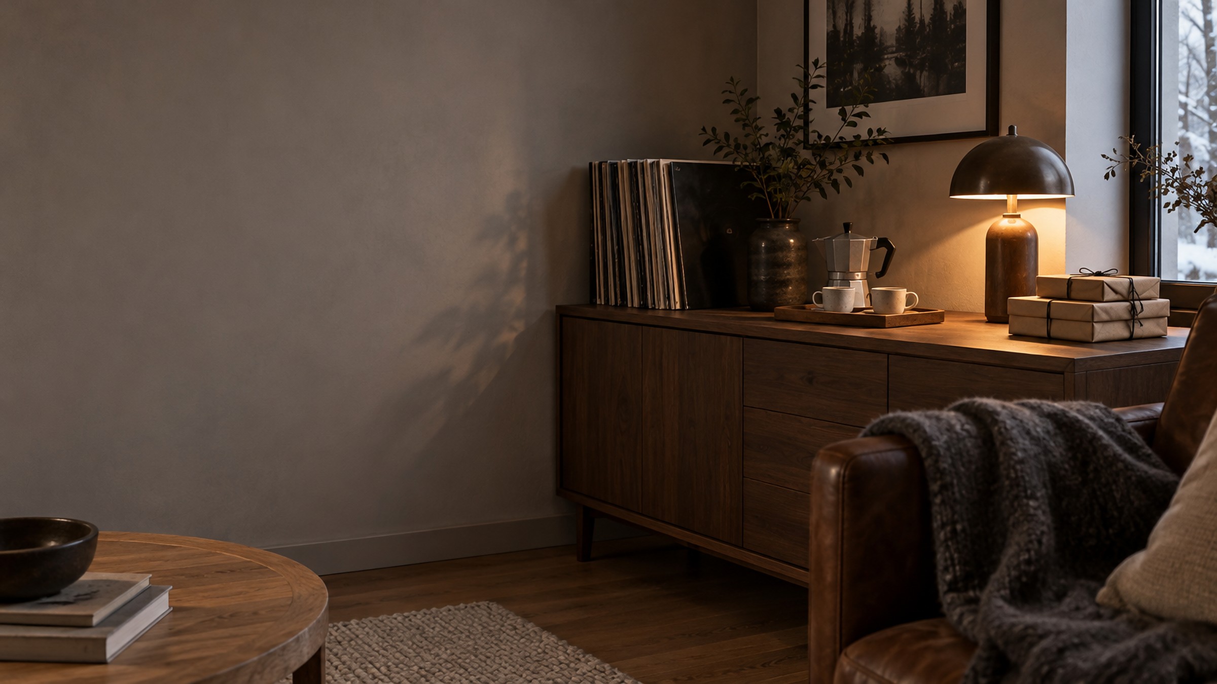 Sideboard mit Schallplatten, Espressokocher und Geschenken in Packpapier am Abend