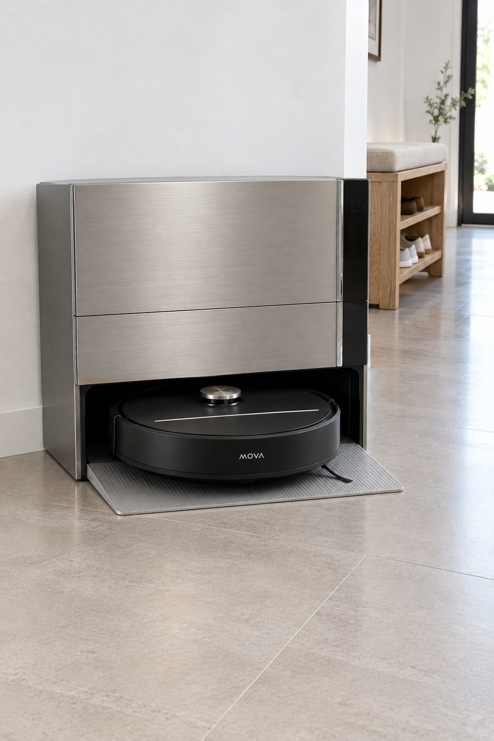 MOVA Z70 Ultra Black: Station mit champagnerfarbener Metallfront, davor der schwarze Saug- und Wischroboter auf der Rampe im hellen Flur mit Fliesen