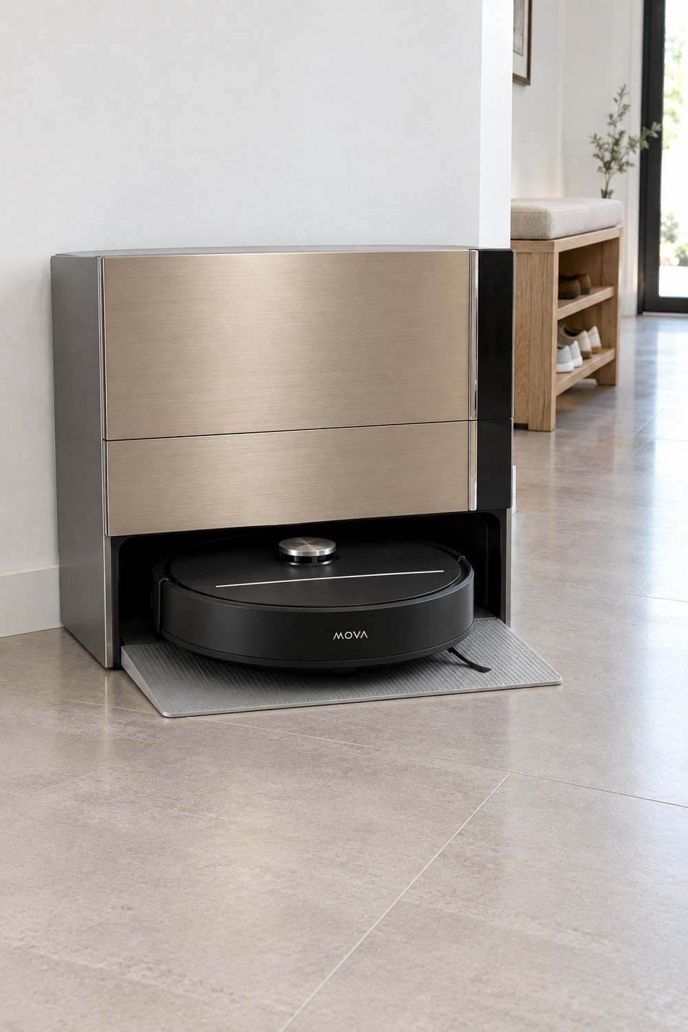MOVA Z70 Ultra Black: Station mit champagnerfarbener Metallfront, davor der schwarze Saug- und Wischroboter auf der Rampe im hellen Flur mit Fliesen